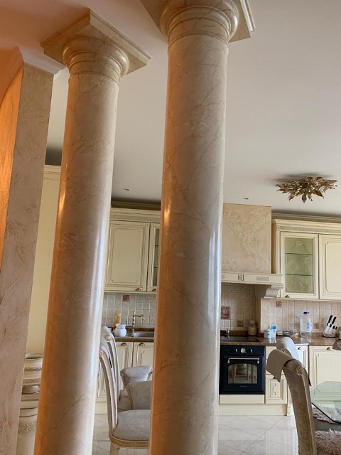 Отделка колонн под мрамор в кухне-столовой